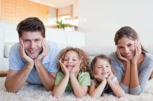 Family lying on a carpet in their living room
